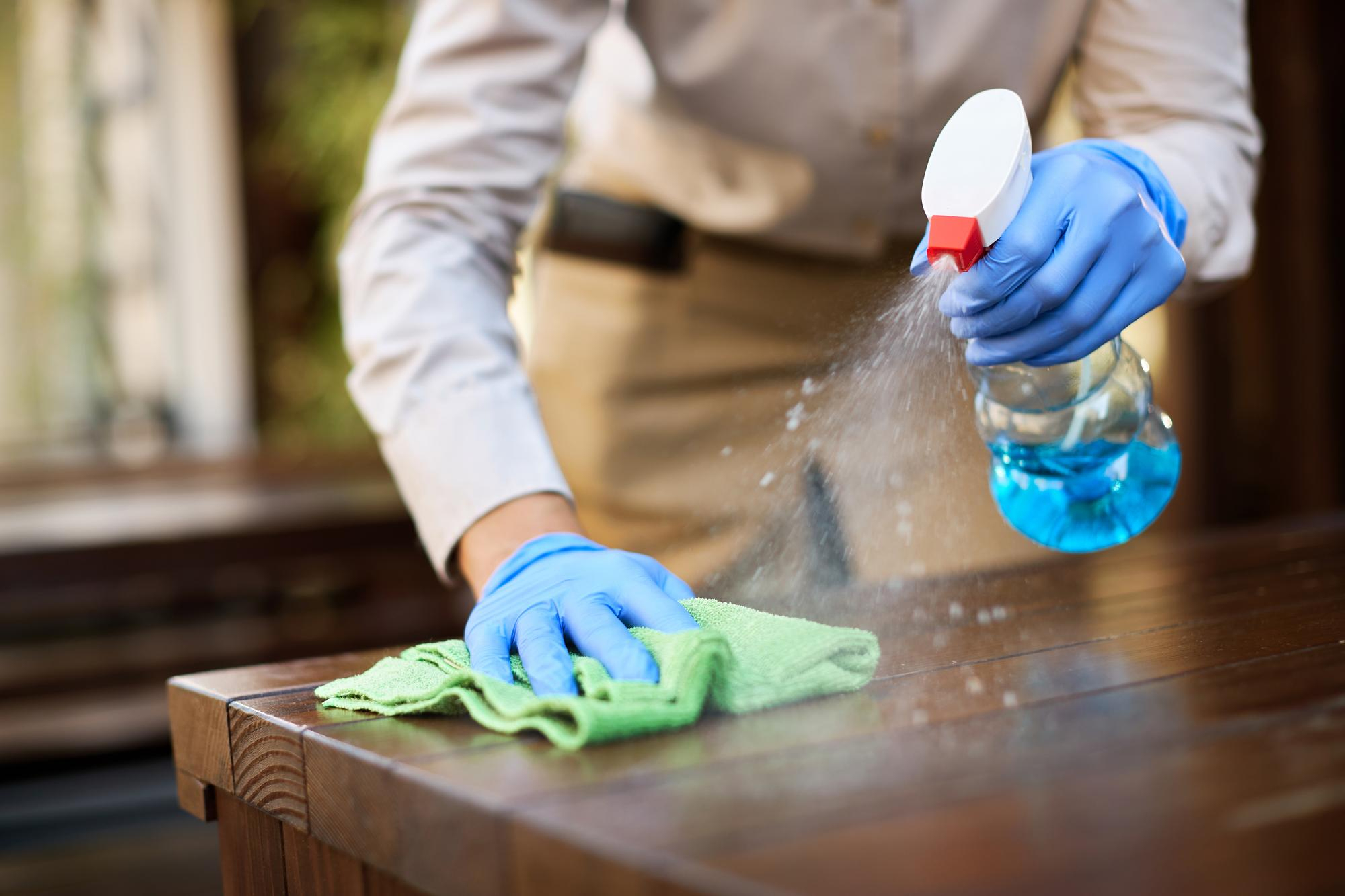 closeup-waitress-disinfecting-tables-outdoor-cafe