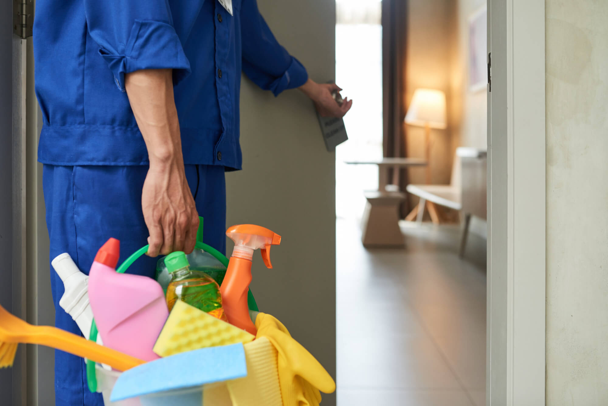 unrecognizable-cleaner-walking-into-hotel-room-with-tools-detergents (1)